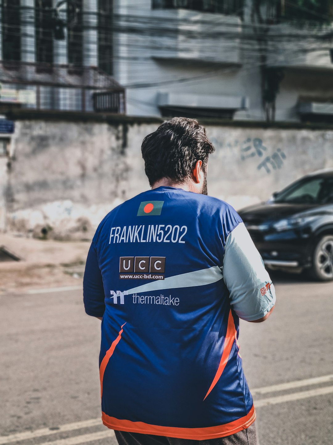 man-in-blue-and-white-adidas-soccer-jersey-standing-on-road-during-daytime-rsvptu2akiy